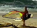 RoyaltyFreeStockVideoSDFootageFemaleWindSurferEntersWateratHookipaBeachinMauiHawaiionaSunnyDay