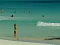 RoyaltyFreeStockVideoSDFootageZoomOuttoScenicViewofCoastlineWavesandPeopleonCancunBeachinMexico